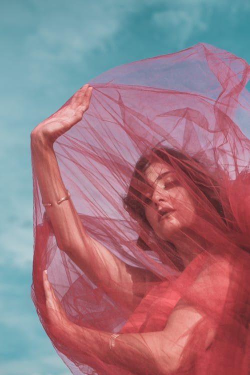 Photo of a Beautiful Woman Covered in a Red Tulle