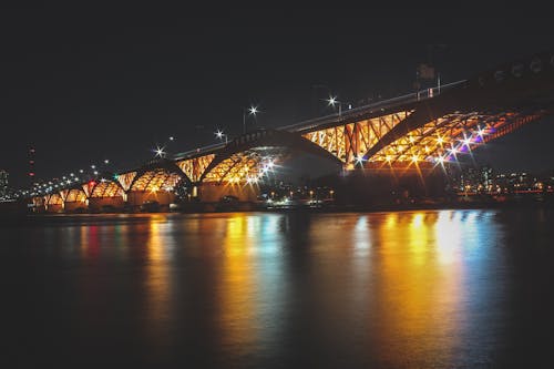 Free A Lighted Bridge over River during Night Time Stock Photo