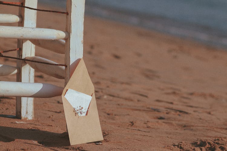 Letter In Envelope On Sand Beach