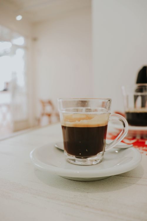 Free Close-up of an espresso in a glass cup on a saucer. Coffee shop ambiance. Stock Photo