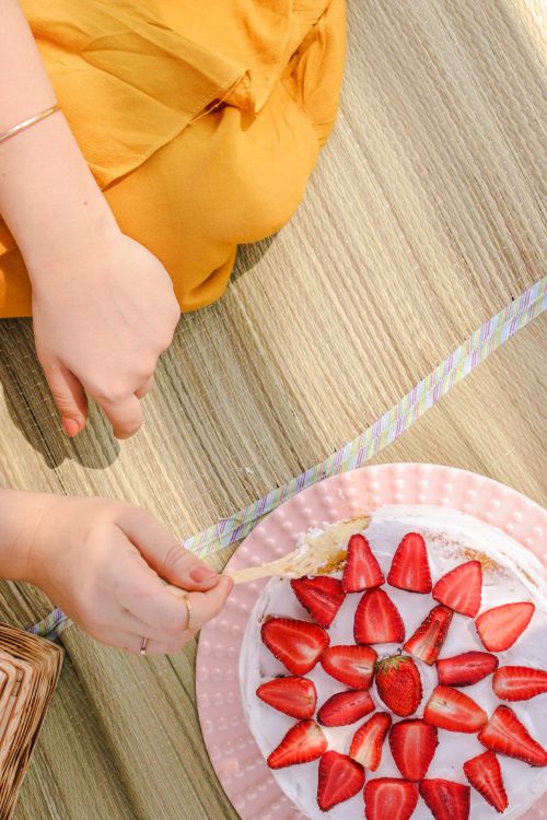 Free Top-down view of a delicious strawberry cake at a casual outdoor summer picnic. Stock Photo
