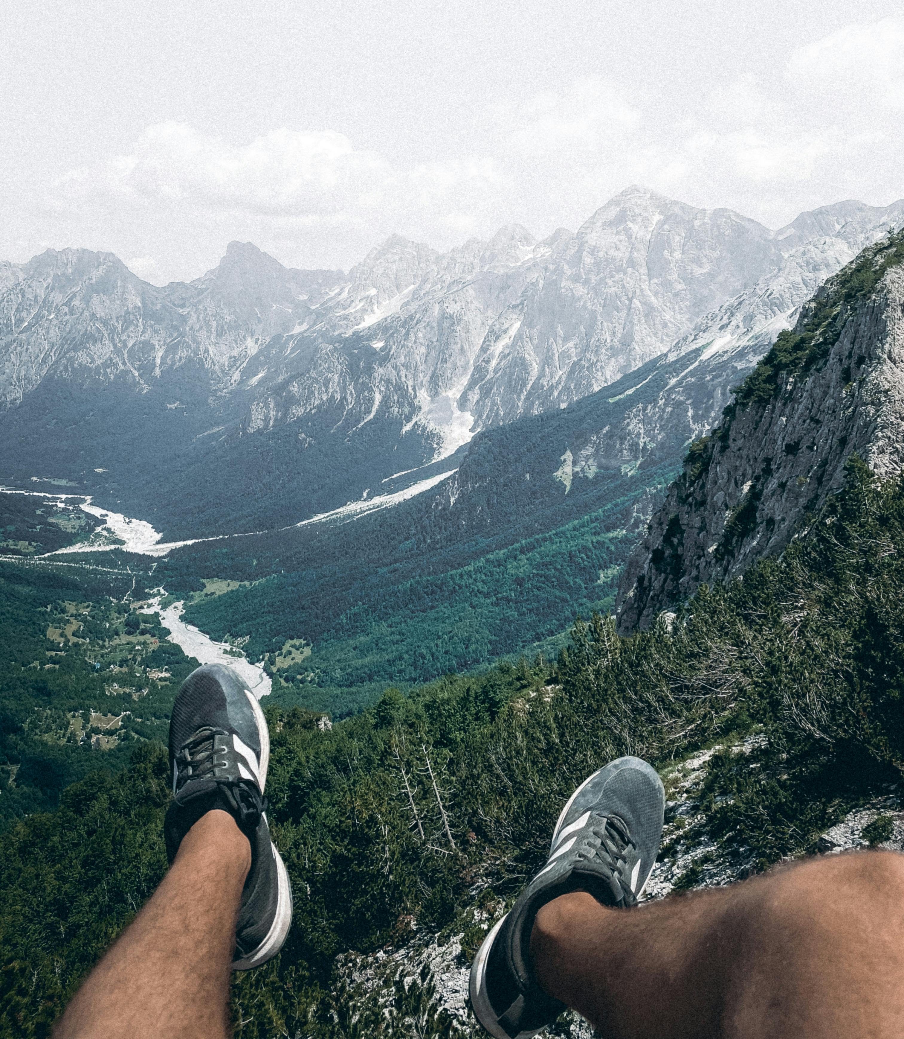 Experience breathtaking mountain views from a hiker's perspective, overlooking lush valleys and majestic peaks.