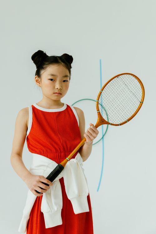 Free Portrait of a young girl holding a badminton racket, showcasing sports spirit in a studio setting. Stock Photo
