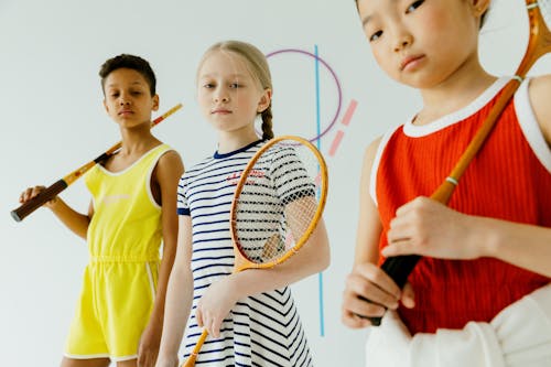 Girls Wearing Dresses Holding Tennis Rackets