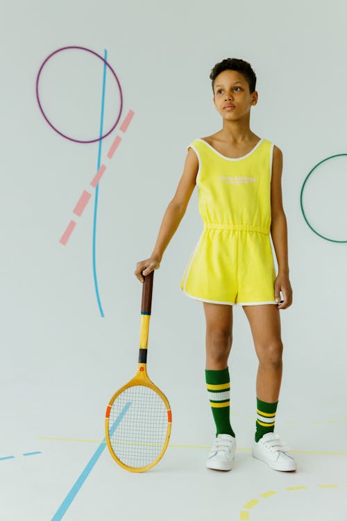 Girl in Yellow Sportswear Holding a Racket