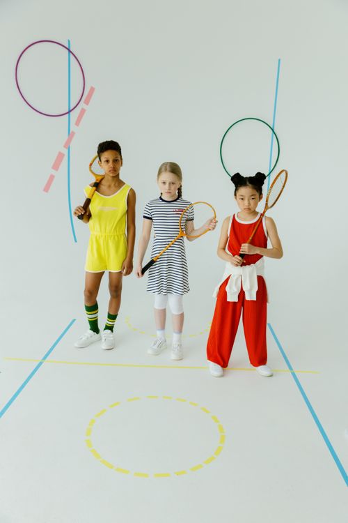 Free Three diverse kids in stylish outfits holding badminton rackets during a studio photo shoot. Stock Photo
