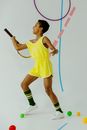 Woman in Yellow Nike Tank Top and Green Shorts Holding Black and White Stick