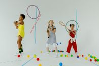 3 Women in Orange and White Dress Playing With Balls