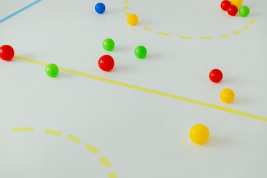 Playful arrangement of colored balls on a marked white surface, featuring vibrant primary colors.