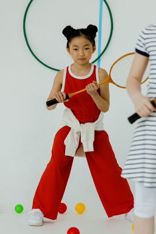 Free Child in sportswear playing racket sport indoors with colorful balls. Stock Photo
