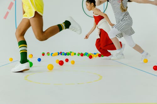 Children Running Among Colorful Balls in the Playroom