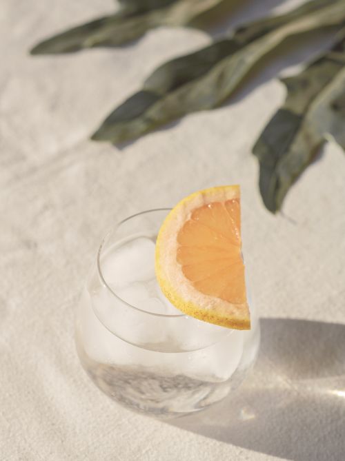 Free Glass of chilled cocktail with grapefruit and ice, set outdoors in a bright, sunny setting. Stock Photo