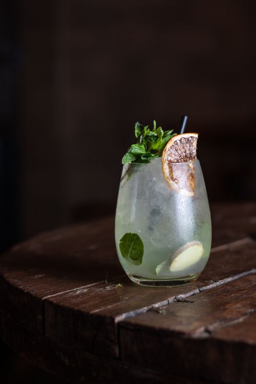 Free Close-up of a citrus mint cocktail with ice in a glass on a wooden table. Stock Photo