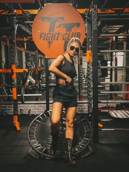 Caucasian woman posing in workout attire at a gym, showing fitness lifestyle.