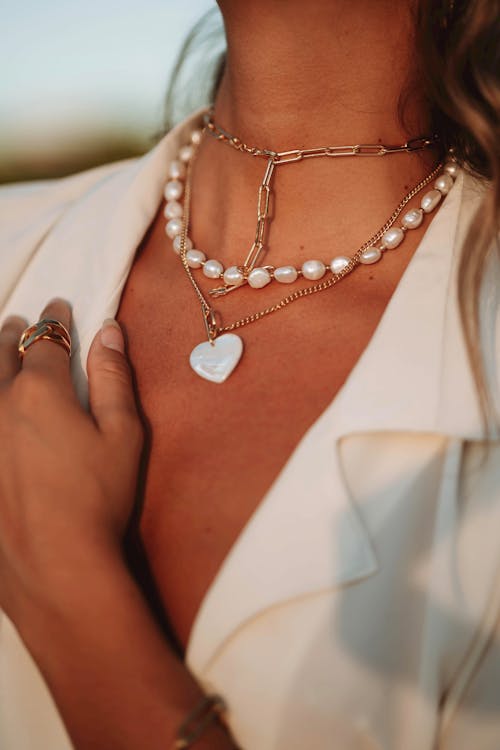 A close up on a womans neck wearing jewelry