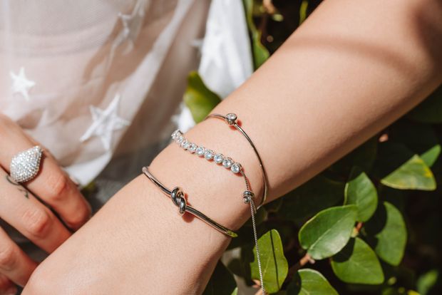 Pulseiras e anel de prata no braço de uma pessoa