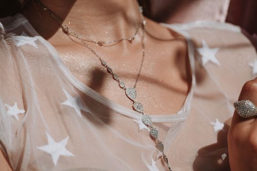 Close-up of a stylish diamond necklace on a star-patterned sheer fabric, capturing elegance.