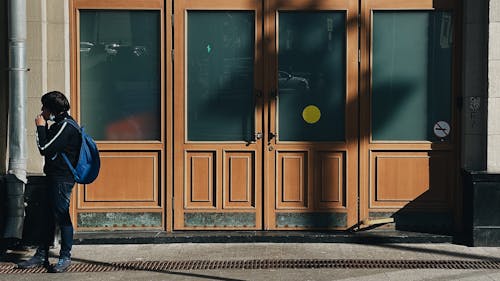 A Man Wearing a Backpack Standing by the Door