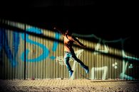 Man with face obscured by shadow jumping