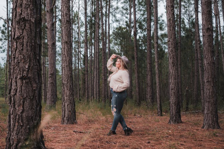 Woman Walking Through Woods Wearing Hat