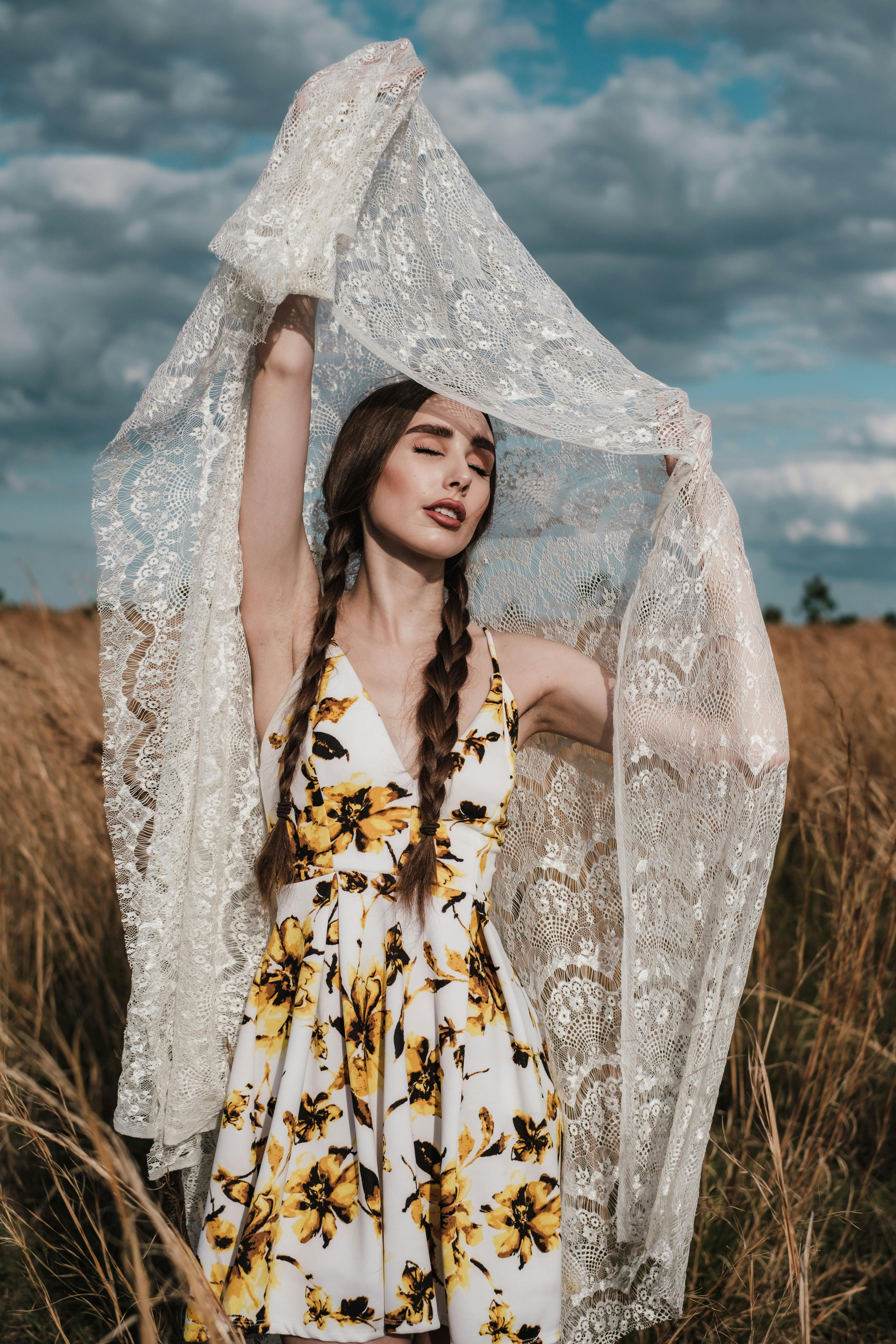 woman in sunflower dress holding up lace fabric