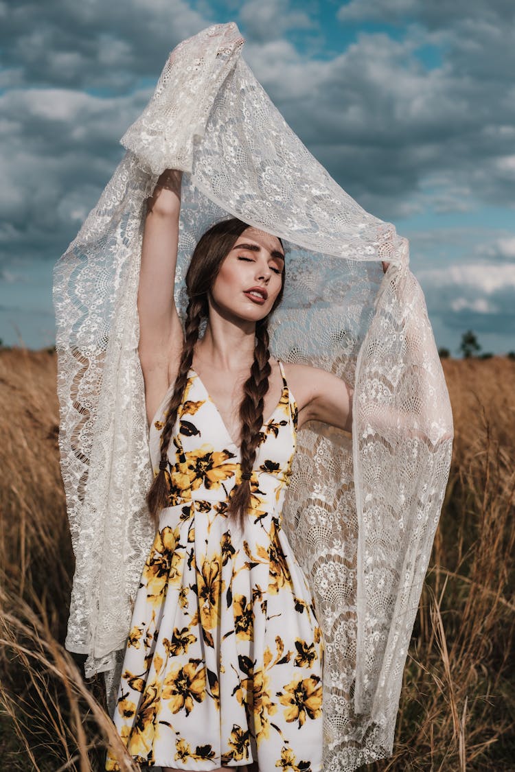 Woman In Sunflower Dress Holding Up Lace Fabric