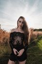 Woman in Black Floral Long Sleeve Shirt Standing on Green Grass Field