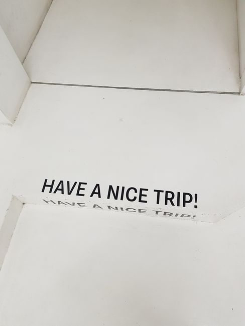 White stairs with the playful text 'Have a Nice Trip!' found in a Bangkok hotel.