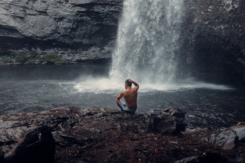 A Shirtless Man Sitting by the Plunge Pool
