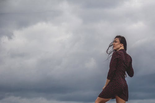 A Woman in a Polka Dot Dress under a Cloudy Sky