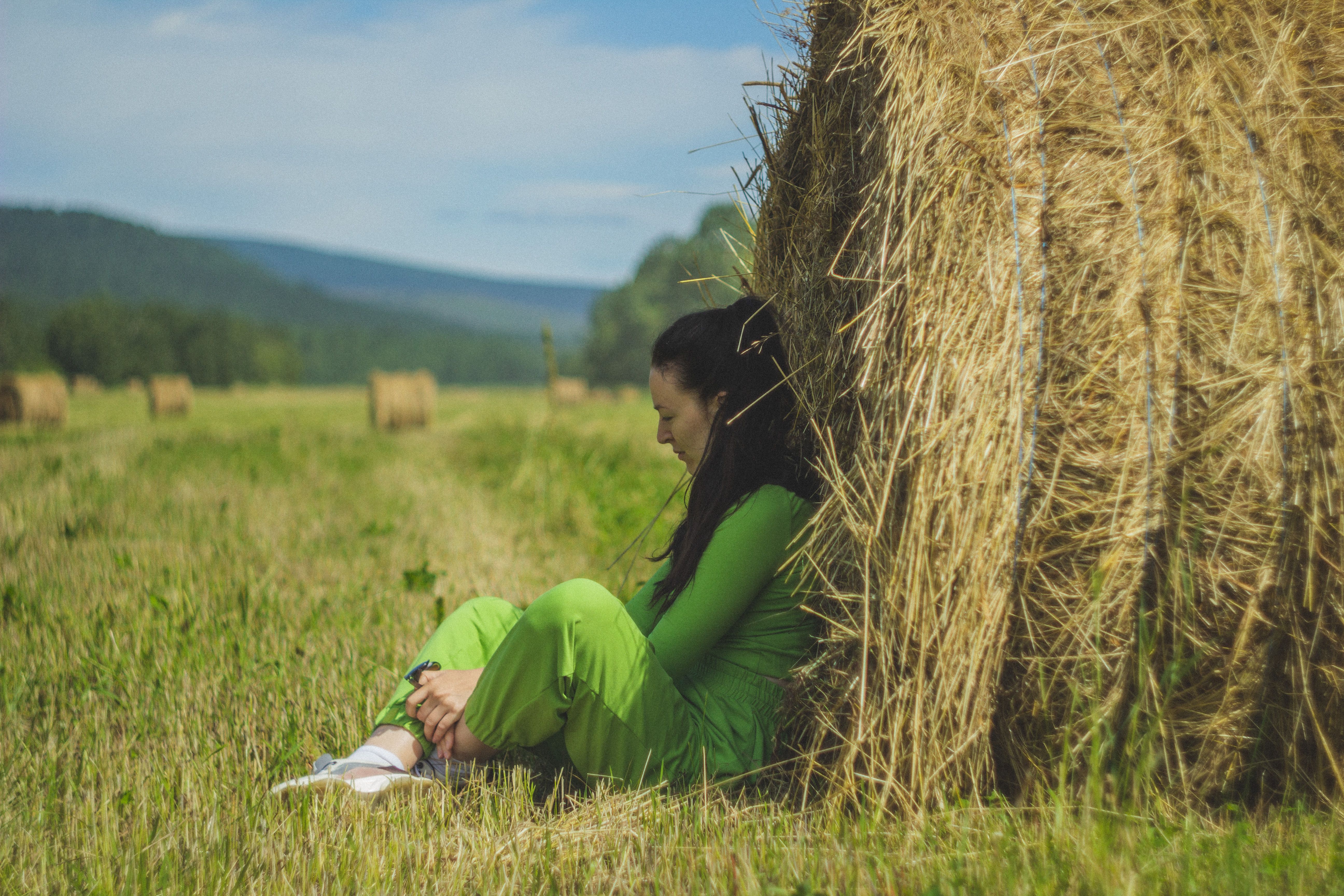 Woman in Green Long Sleeve Shirt Sitting on Grass Field · Free Stock Photo
