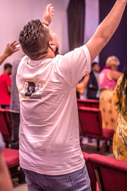 Free A man raising his hands in prayer during a church service, expressing devotion. Stock Photo