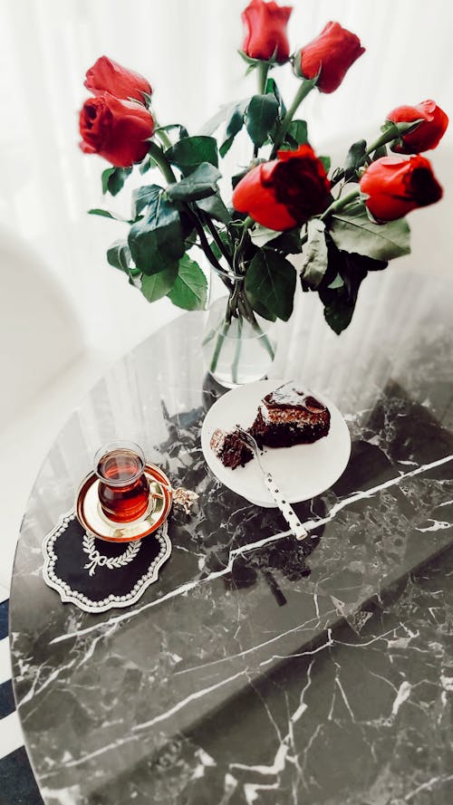 Tea, Cake and Red Roses on a Table 