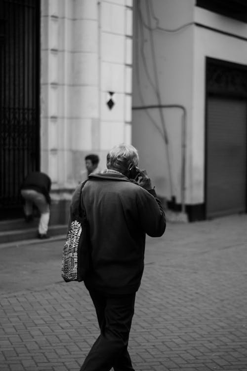 Free Grayscale Photo of Man in Black Jacket Standing Near Wall Stock Photo