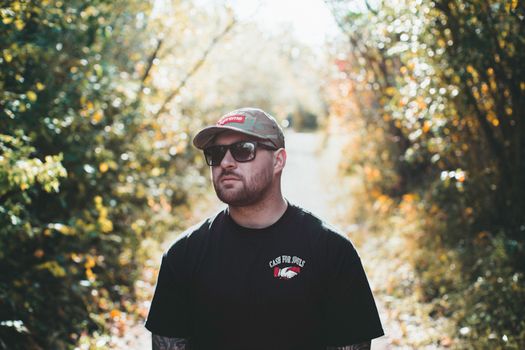 A Man in Black Shirt and Cap with Sunglasses