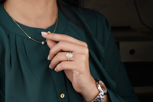 Woman in Green Long Sleeves Wearing Silver Diamond Ring