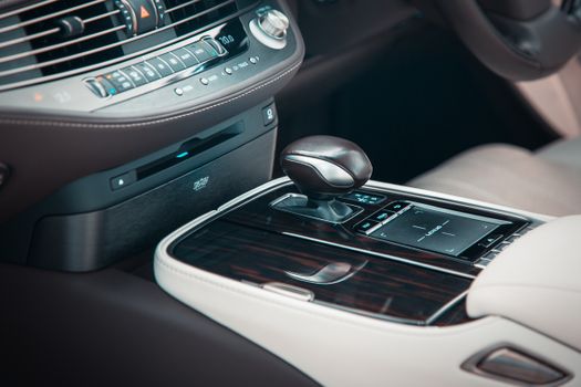 Detailed view of a premium car interior featuring a gear shift and polished wooden trim.