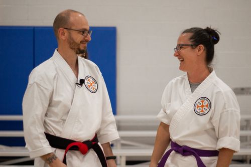 Free Smiling karate instructors in a dojo sharing a light-hearted moment. Stock Photo