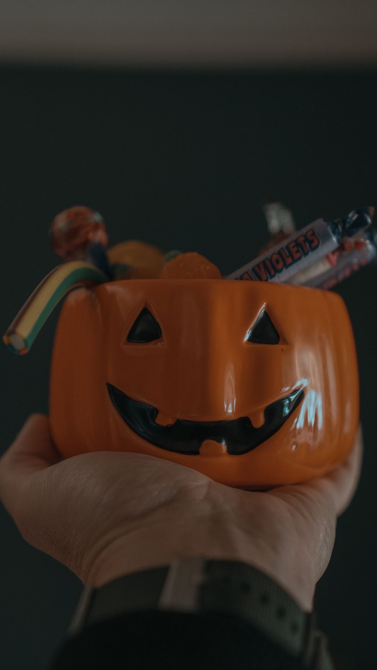 Pumpkin candy bowl filled with wrapped trick-or-treat candy