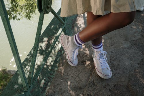 Legs of girl standing on bridge