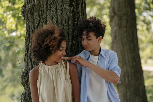 Free Interracial couple enjoying a moment of love and connection in a scenic park setting. Stock Photo