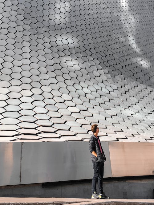 Man in Jacket Standing by Building Wall