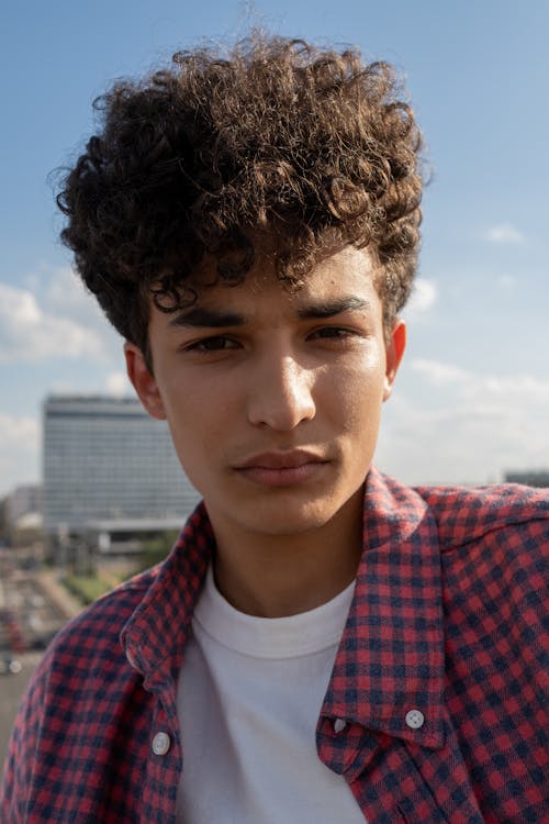 Portrait of teenage boy with curly hair · Free Stock Photo