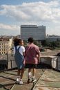 Teenage couple on date standing on rooftop and girl smiling to boy