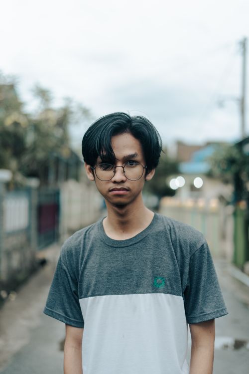 Free Casual portrait of a young man with eyeglasses in an urban alleyway Stock Photo