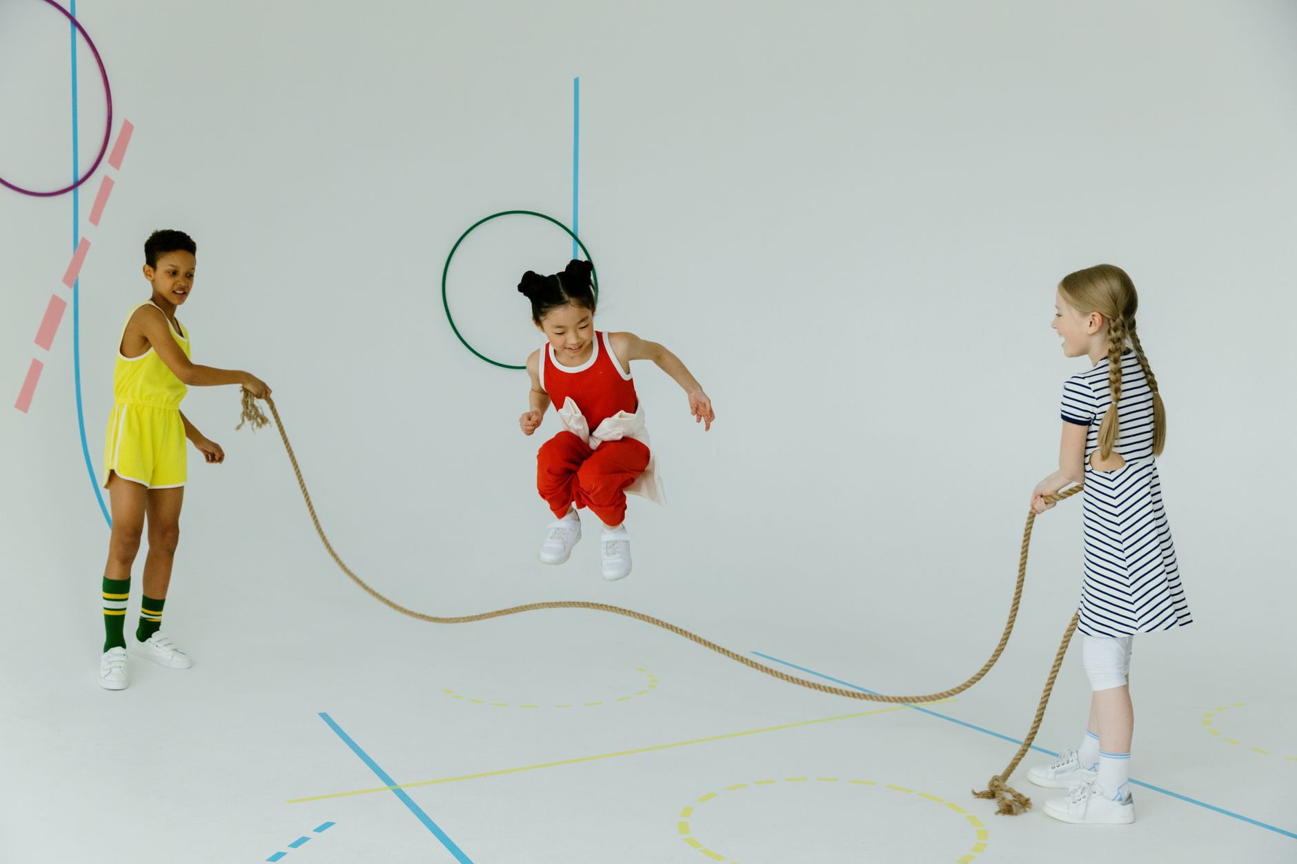 Get Lean Fast: Top Jump Rope Workouts 1 Joyful group of diverse children skipping rope indoors, enjoying playful activity and friendship.