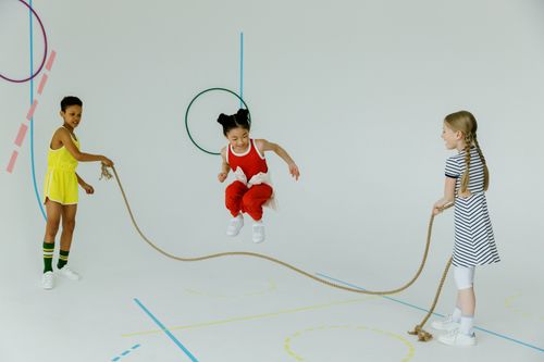 Free Joyful group of diverse children skipping rope indoors, enjoying playful activity and friendship. Stock Photo