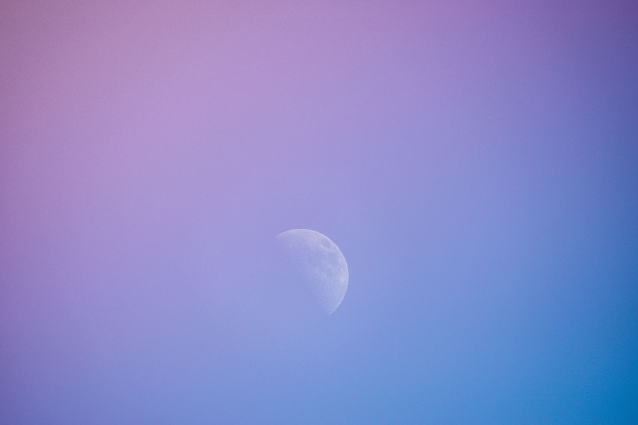 half moon amid a beautiful gradient sky blending purple and blue hues