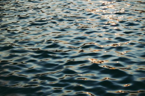 Free Glistening ocean waves shimmering under sunlight, creating captivating reflections. Stock Photo