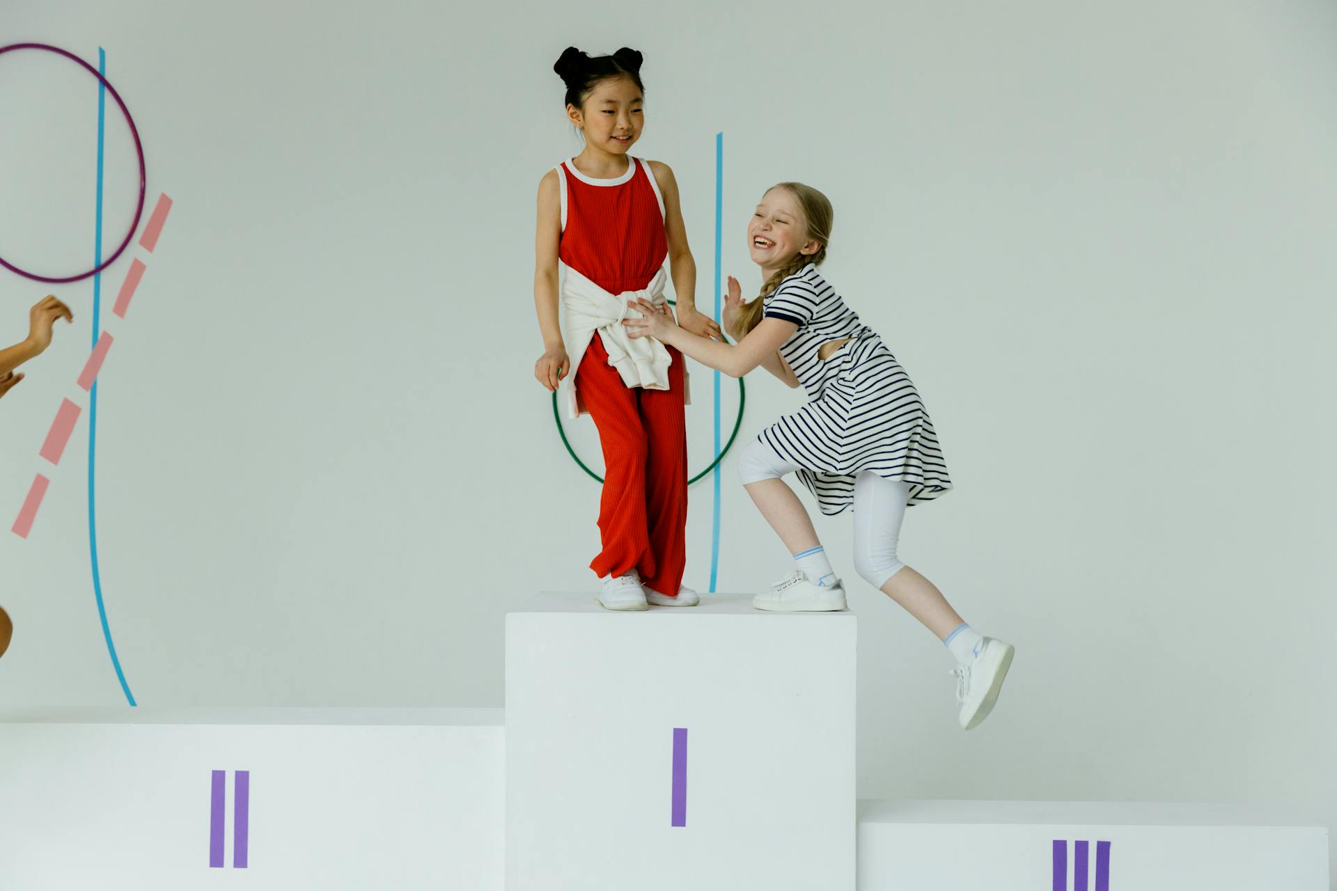Two happy children celebrating on a winners podium, showcasing joy and friendship.